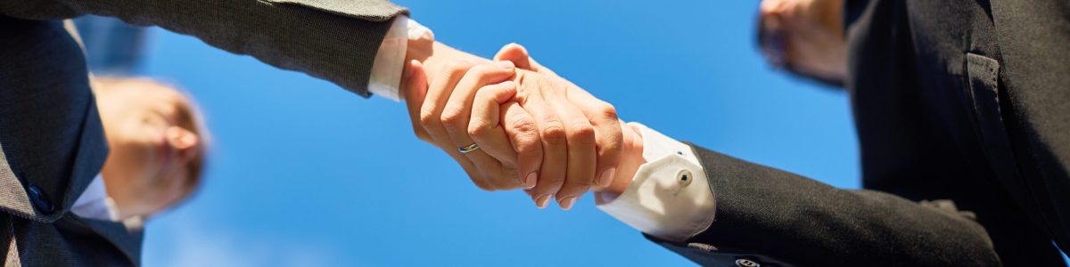Hands of partners Handshake of partners and blue sky above
